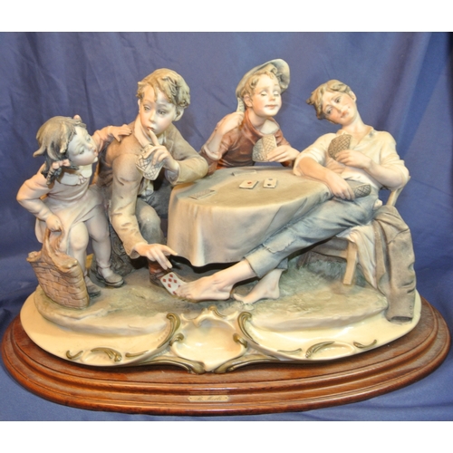 127 - Ornate Capodimonte group of card players, on scroll decorated base on timber stand