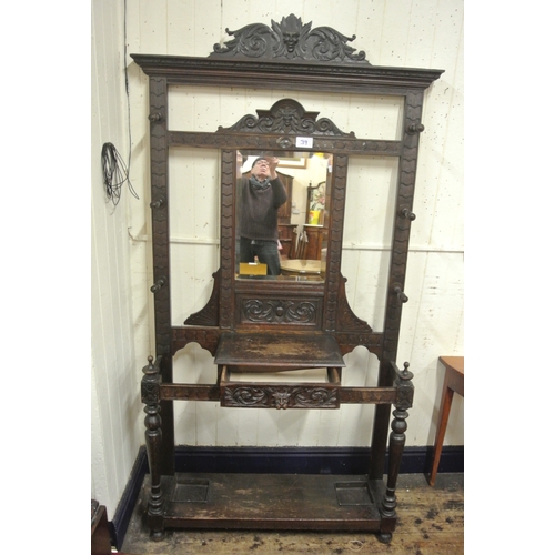 125 - Arts & Crafts oak hallstand with scroll and figured decoration, mirror inset, glove drawer, and turn... 