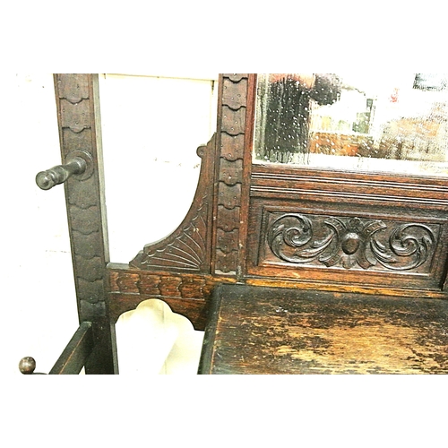 125 - Arts & Crafts oak hallstand with scroll and figured decoration, mirror inset, glove drawer, and turn... 