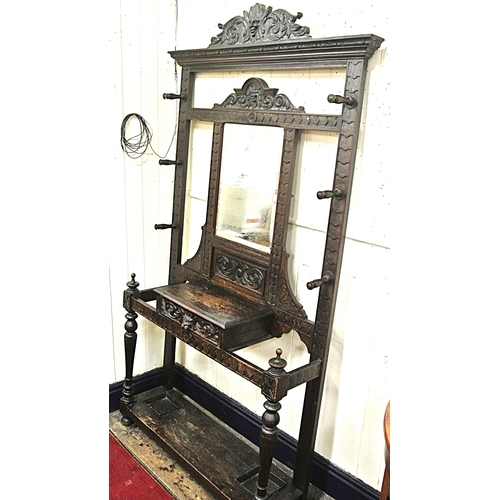 125 - Arts & Crafts oak hallstand with scroll and figured decoration, mirror inset, glove drawer, and turn... 
