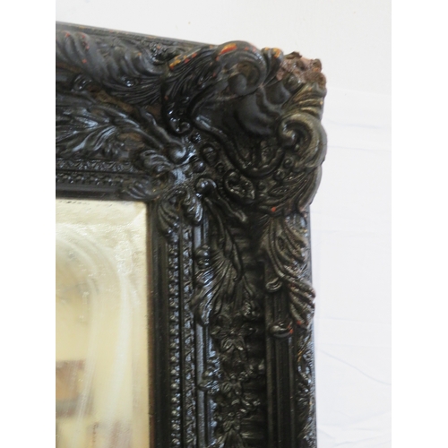 161 - Large black framed bevelled glass mirror with foliate and reeded decoration