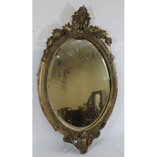 93 - Victorian style oval bevelled glass gilt framed mirror with ornate foliate and scroll decoration