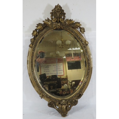 93 - Victorian style oval bevelled glass gilt framed mirror with ornate foliate and scroll decoration
