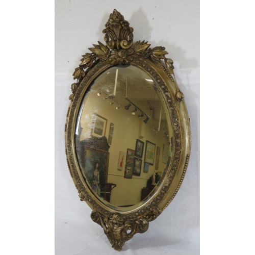 93 - Victorian style oval bevelled glass gilt framed mirror with ornate foliate and scroll decoration