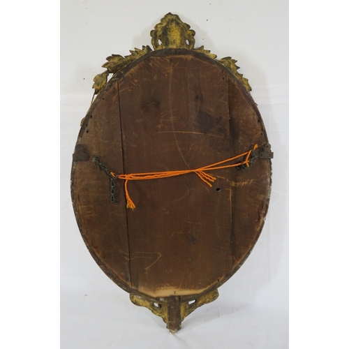 93 - Victorian style oval bevelled glass gilt framed mirror with ornate foliate and scroll decoration