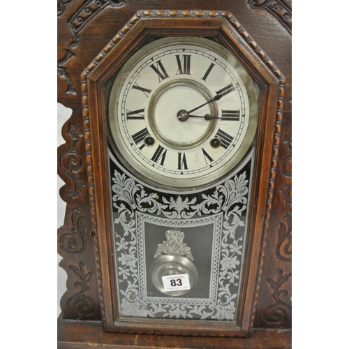 83 - Oak cased mantle clock with foliate decoration, round enamel dial and pendulum