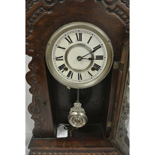 83 - Oak cased mantle clock with foliate decoration, round enamel dial and pendulum