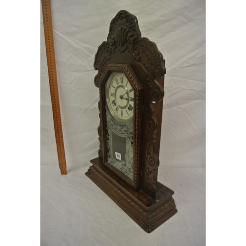 83 - Oak cased mantle clock with foliate decoration, round enamel dial and pendulum
