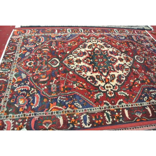 146 - Rich red and blue ground Persian Baktia village carpet with central medallion, 295x200cm