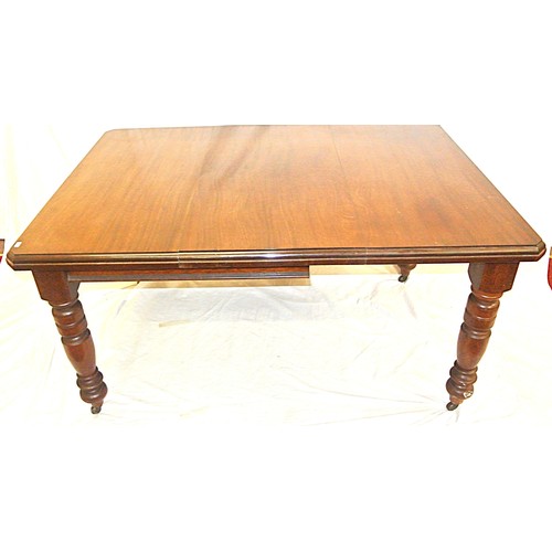 105 - Edwardian mahogany dining table with leaf inset, angled corners, on turned tapering legs with caster... 