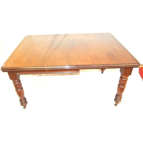 105 - Edwardian mahogany dining table with leaf inset, angled corners, on turned tapering legs with caster... 