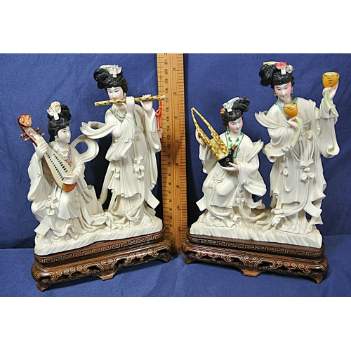 328 - Pair of Oriental figured groups of musical Geishas, holding musical instruments, on inlaid timber ba... 