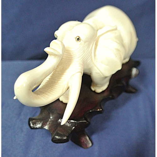 335 - Oriental figurine of an Elephant on shaped timber base