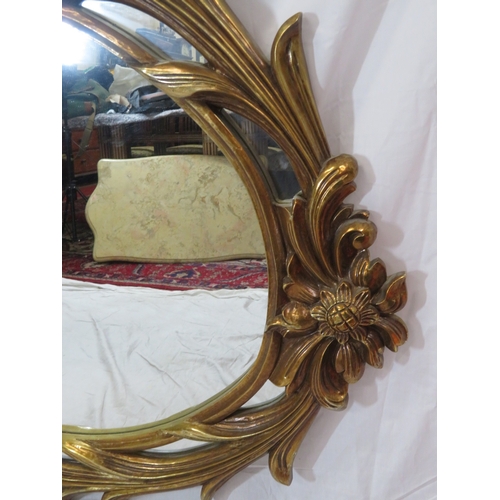462 - Large ornate oval gilt mirror in scroll & foliate decorated frame, 180 x120 cm
