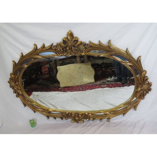 462 - Large ornate oval gilt mirror in scroll & foliate decorated frame, 180 x120 cm