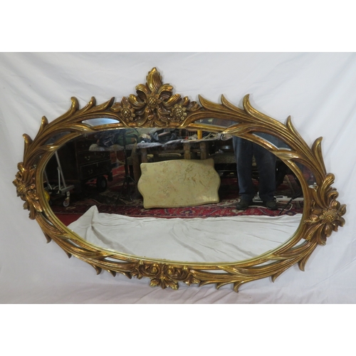 462 - Large ornate oval gilt mirror in scroll & foliate decorated frame, 180 x120 cm
