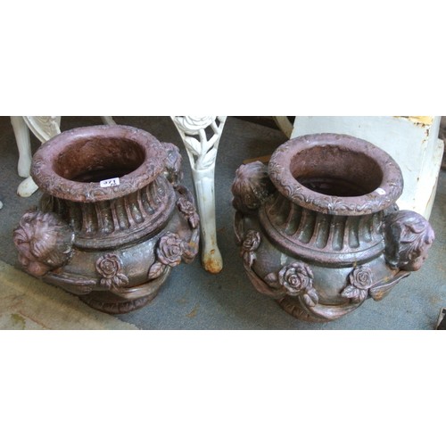 476 - Pair of ornate cast iron round garden vases with figured and foliate decoration and round bases