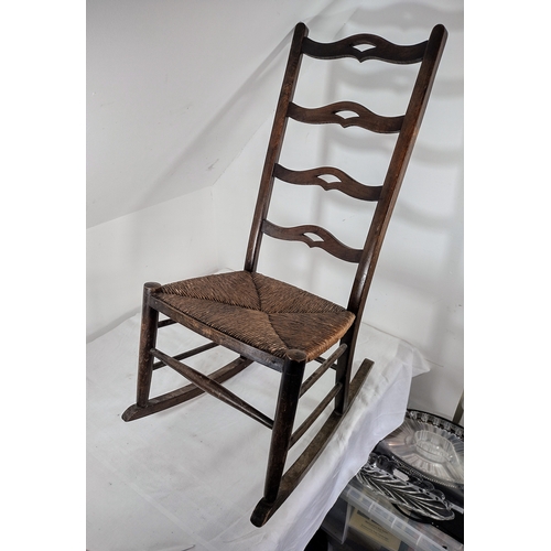 69 - Antique Ladderback Rocking Chair with Woven Rush Seat, Featuring Curved Back Rails and Rustic Wooden... 