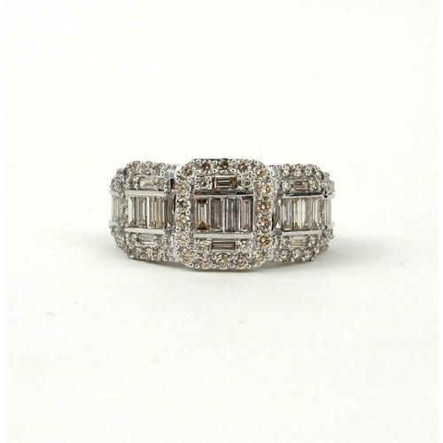 14 - A LARGE GRADUATED DIAMOND CLUSTER RING SET WITH BAGUETTE CUT AND ROUND BRILLIANT CUT DIAMONDS. 
(Dia... 