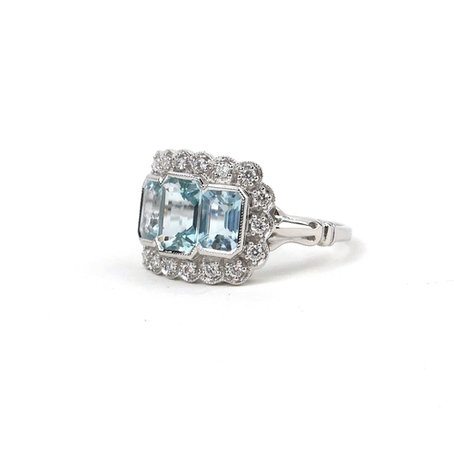 52 - AN 18CT WHITE GOLD THREE STONE AQUAMARINE AND DIAMOND DRESS RING.  (Aquamarine 2.10ct, Diamonds 0.26... 