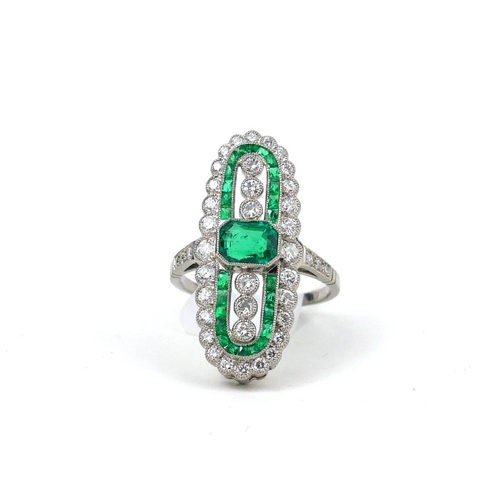 43 - A FINE QUALITY PLATINUM ELONGATED OVAL SHAPED DRESS RING set with emeralds and diamonds.  
(Emeralds... 