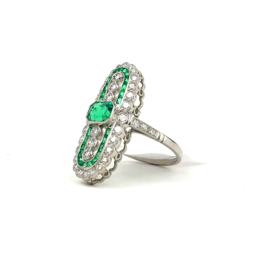 43 - A FINE QUALITY PLATINUM ELONGATED OVAL SHAPED DRESS RING set with emeralds and diamonds.  
(Emeralds... 