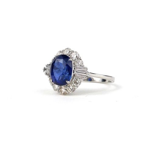 41 - AN 18CT WHITE GOLD RING SET WITH AN OVAL BLUE SAPPHIRE, tapered baguette cut diamonds and round bril... 