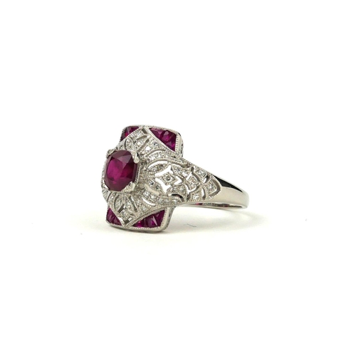 37 - A VICTORIAN STYLE RUBY AND DIAMOND DRESS RING with a pierced ornate setting set in platinum.  
Rubie... 