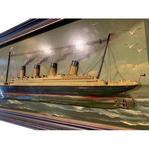 115 - A 20TH CENTURY PAINTED AND CARVED WOOD DIORAMA, THE TITANIC
Held in an ebonised and parcel gilt fram... 