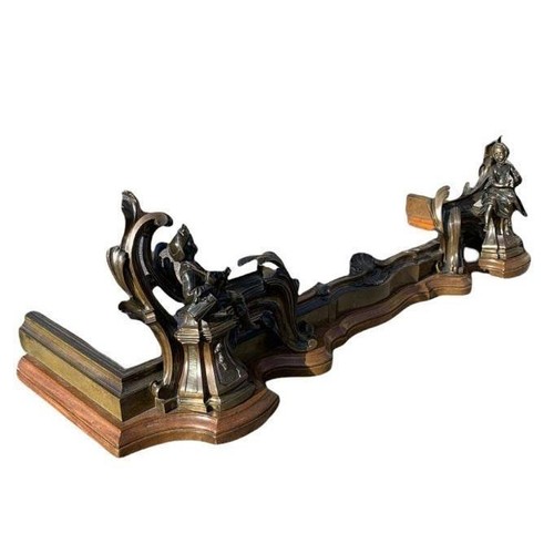 131 - A 19TH CENTURY FRENCH BRONZE FIGURAL CHENET
The serpentine rail cast with a central shell and leaves... 