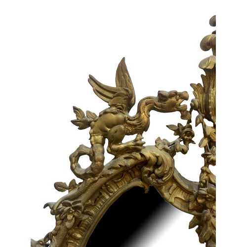 152 - A LARGE EARLY 19TH CENTURY GILTWOOD AND GESSO ROCOCO MIRROR
The cartouche form frame decorated with ... 