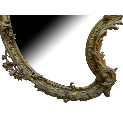 152 - A LARGE EARLY 19TH CENTURY GILTWOOD AND GESSO ROCOCO MIRROR
The cartouche form frame decorated with ... 