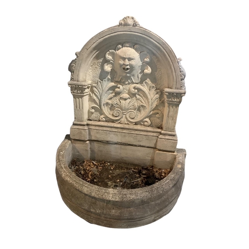 176 - A DECORATIVE PAINTED STONE WATER FOUNTAIN
The arch top with central facial mask surrounded foliage d... 