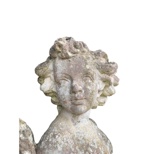 180 - A 19TH CENTURY RECONSTITUTED MARBLE STATUE, PUTTI HOLDING A WHEATSHEAF RECLINING
On an acanthus leaf... 