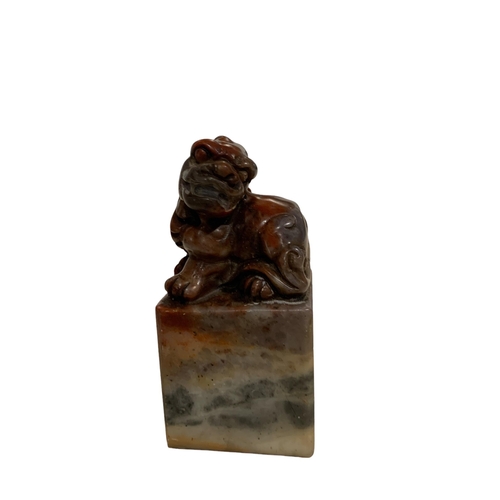 65 - A CHINESE JADE SEAL, surmounted by the figure of a lion dog, character seal to base. 
H- 6.9cm W-3.5... 