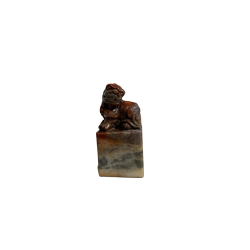 65 - A CHINESE JADE SEAL, surmounted by the figure of a lion dog, character seal to base. 
H- 6.9cm W-3.5... 