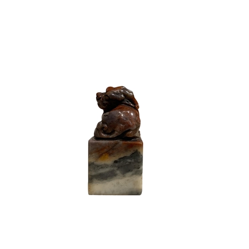 65 - A CHINESE JADE SEAL, surmounted by the figure of a lion dog, character seal to base. 
H- 6.9cm W-3.5... 