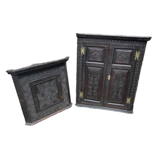 110 - TWO 18TH CENTURY CARVED OAK CORNER CABINETS
The panelled doors applied with brass fittings, opening ... 