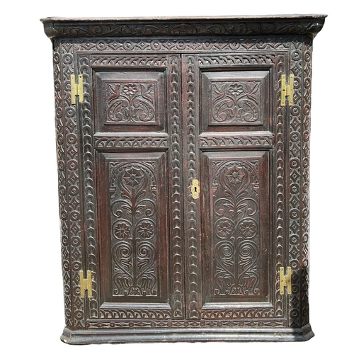 110 - TWO 18TH CENTURY CARVED OAK CORNER CABINETS
The panelled doors applied with brass fittings, opening ... 