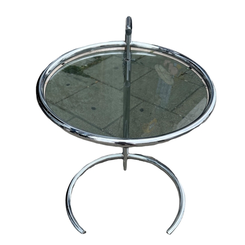 264 - AN EILEEN GRAY DESIGN CIRCULAR CHROME AND GLASS ADJUSTABLE TABLE. 
(h 52cm x diameter 51cm)