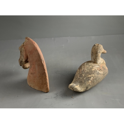 289 - A POTTERY HORSE'S HEAD AND A DUCK, HAN DYNASTY (BC 206 - AD 220)
The grey pottery applied with a red... 