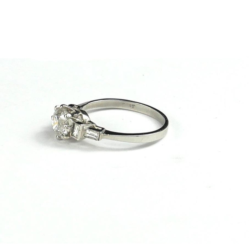 24 - A PLATINUM SOLITAIRE DIAMOND RING
Flanked by baguette diamond shoulders, with WGI certificate.
(RBC ... 