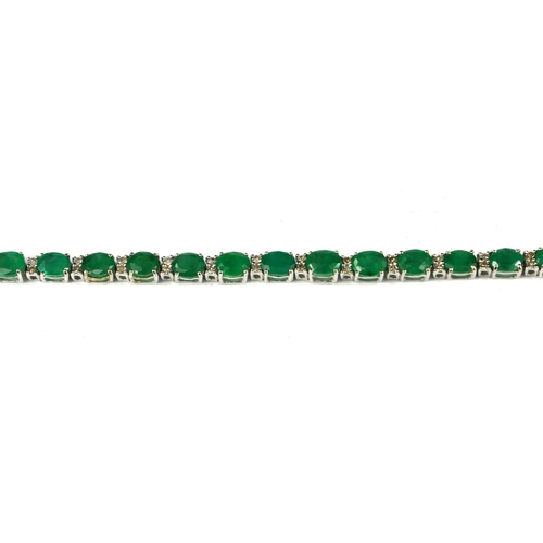 40 - AN 18CT WHITE GOLD, OVAL CUT EMERALD AND DIAMOND LINE BRACELET.  
(approx emeralds 8.95ct, diamonds ... 