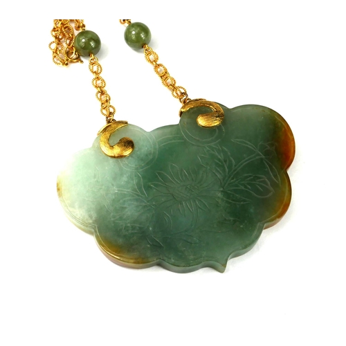 5 - A LARGE 14CT GOLD AND CARVED JADE PENDANT 
Suspended by a jade and gold link necklace.
(gross weight... 