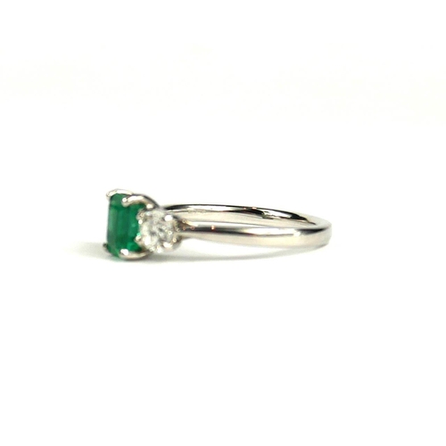 78A - AN 18CT WHITE GOLD EMERALD AND DIAMOND THREE STONE RING.  (Emerald 0.82ct, Diamonds 0.60ct)