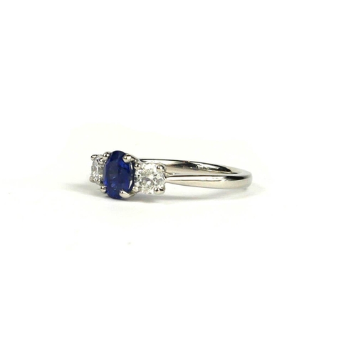 90A - A PLATINUM THREE STONE RING set with oval sapphire and round brilliant cut diamonds.  (Sapphire 0.92... 