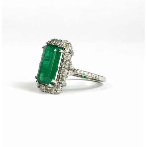 92A - AN 18CT WHITE GOLD EMERALD AND DIAMOND CLUSTER RING.  (Emerald 3.72ct, Diamonds 1.17ct)