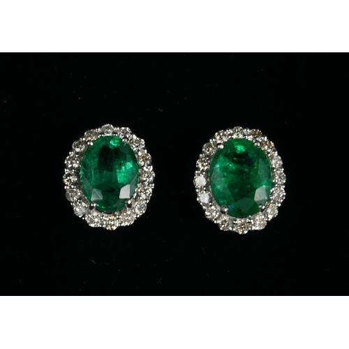 97A - A PAIR OF 18CT WHITE GOLD OVAL EMERALD AND DIAMOND CLUSTER STUDS,  Boxed.  (Emeralds 3.96ct, Diamond... 