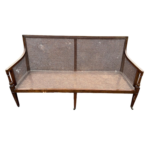 219 - A 19TH CENTURY MAHOGANY BERGÈRE SETTEE
With cane back arms and seat, raised on three square tapering... 