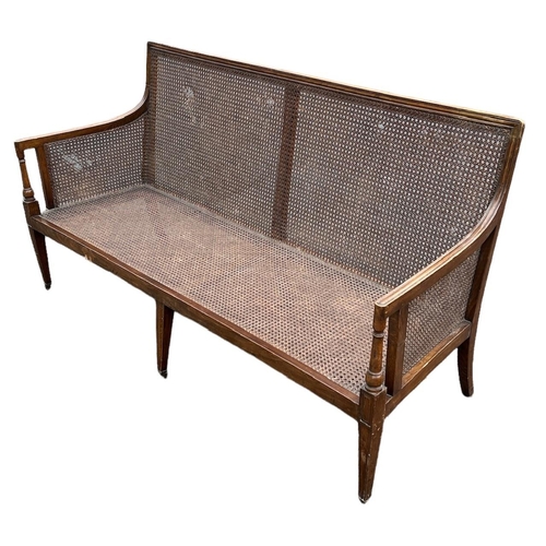 219 - A 19TH CENTURY MAHOGANY BERGÈRE SETTEE
With cane back arms and seat, raised on three square tapering... 